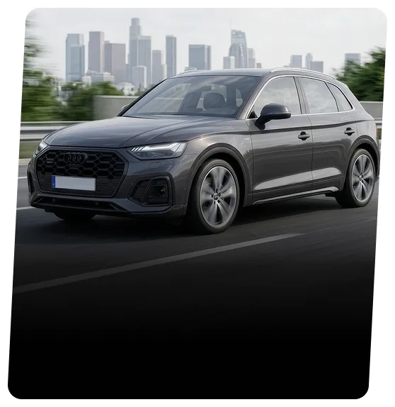 Dark grey Audi SUV driving on a highway with a city skyline behind