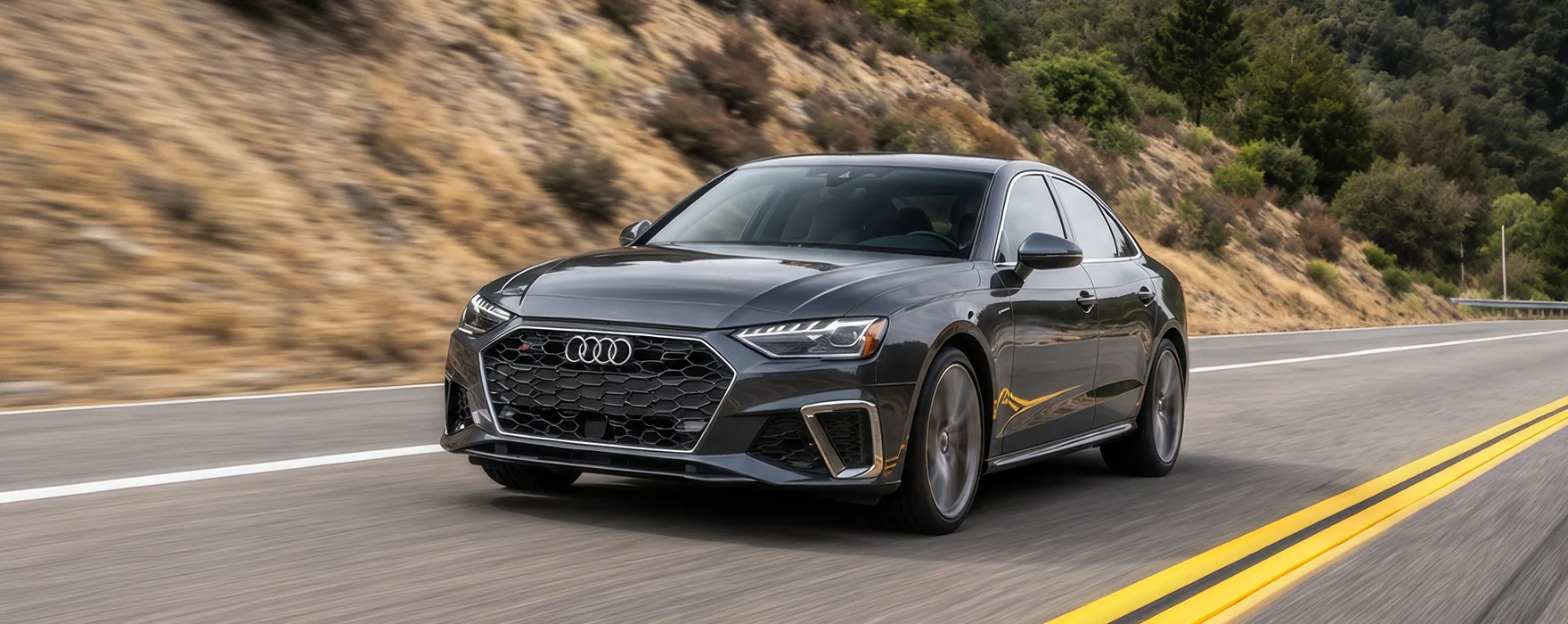 Grey Audi sedan driving a winding mountain road