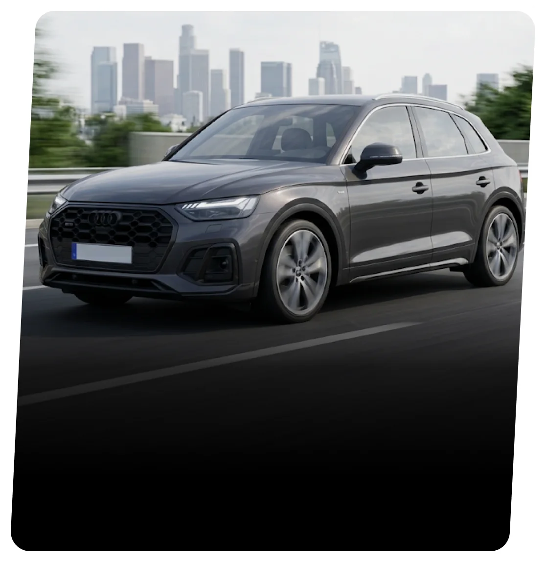 Dark grey Audi SUV driving on a highway with a city skyline behind