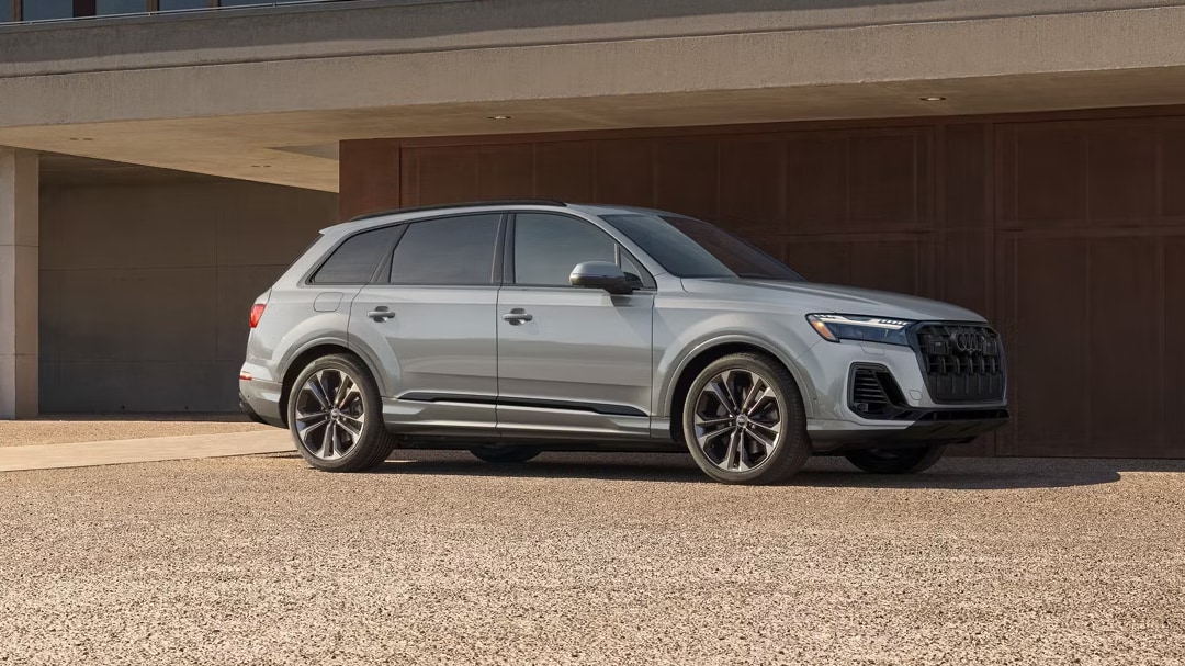 Side view Audi Q7 2025, parked in front of a building