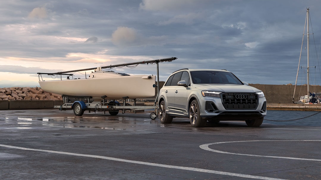 3/4 front and side view of Audi !Q7 2025 towing a boat