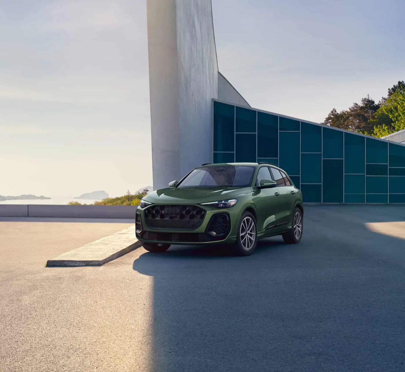 2026 Audi Q5 exterior front three-quarter view beside a glass pavilion