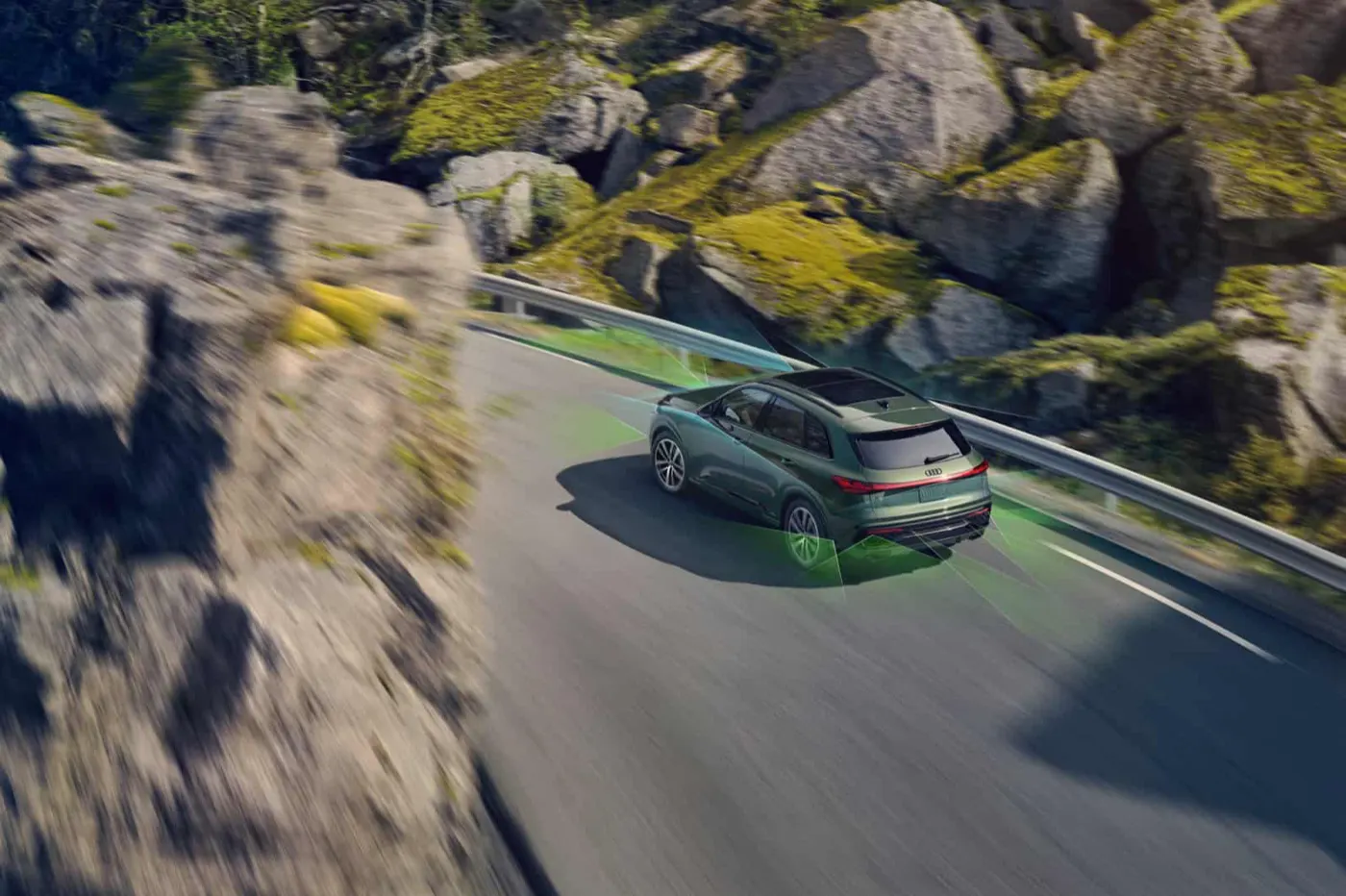 2026 Audi Q5 driving a coastal mountain road with driver-assistance sensor coverage illustrated