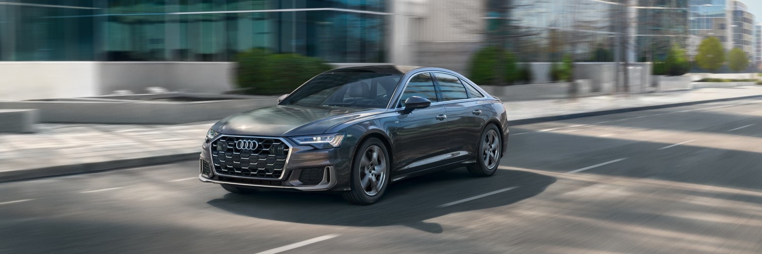 Audi A6 driving down a city street