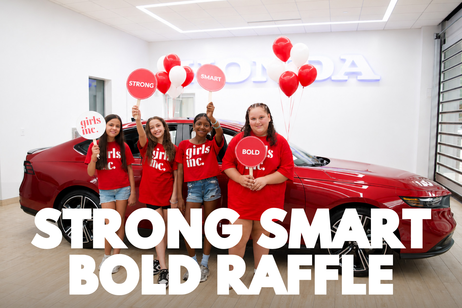 Girls Inc. members in red shirts holding Strong, Smart and Bold signs in front of a Radiant Red Honda Accord Hybrid at AutoFair Honda