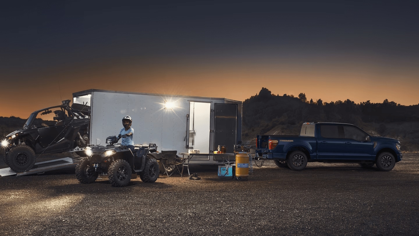 The Ford F-150 is a versatile family vehicle with modern comfort & technology features Exterior shot of a Ford F-150 parked while an ATV exits out of trailer