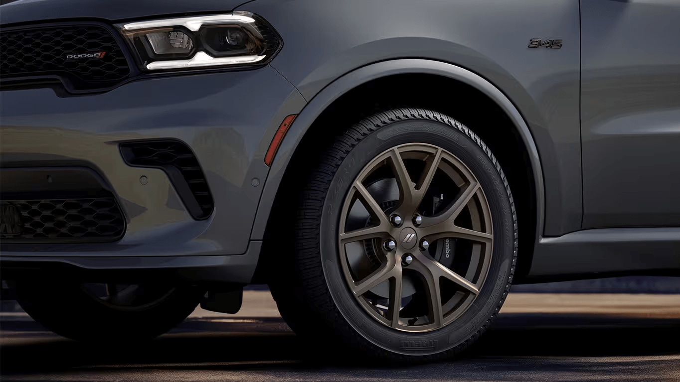 Learn about the exterior design of the Dodge Durango Closeup shot of the Dodge Durango's exterior showing the left headlight, part of the front grille, and front-left tire