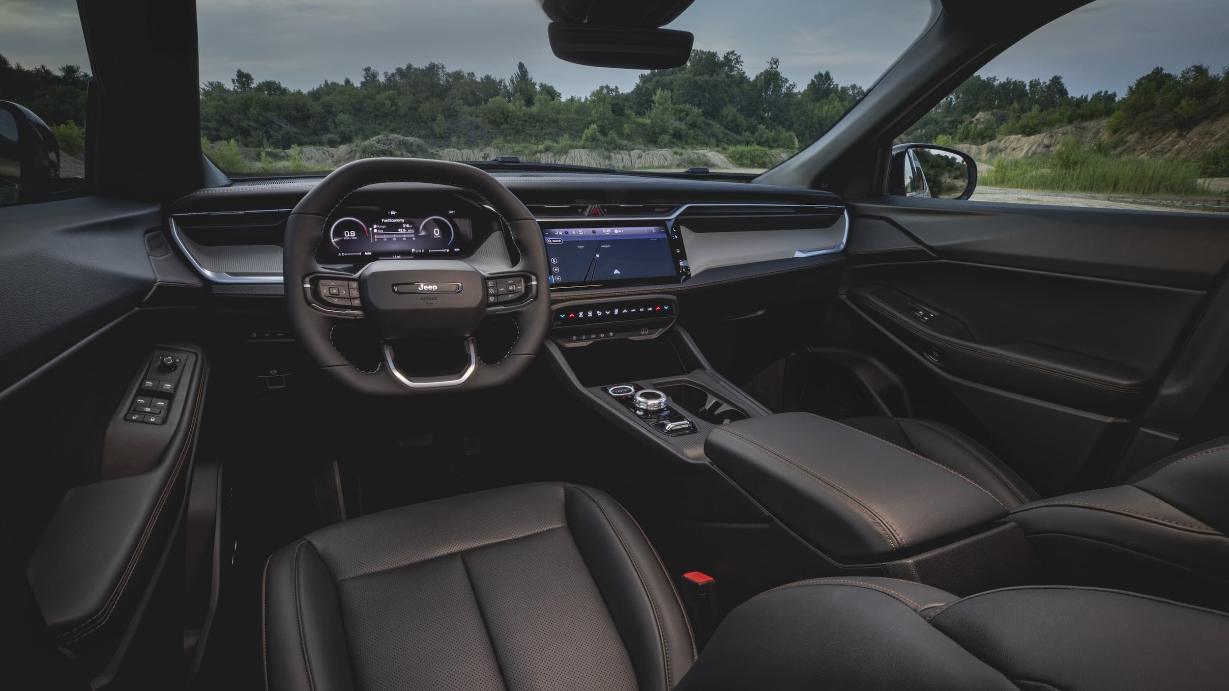  The interior of the Jeep Cherokee from the driver's seat, including the steering wheel and center console