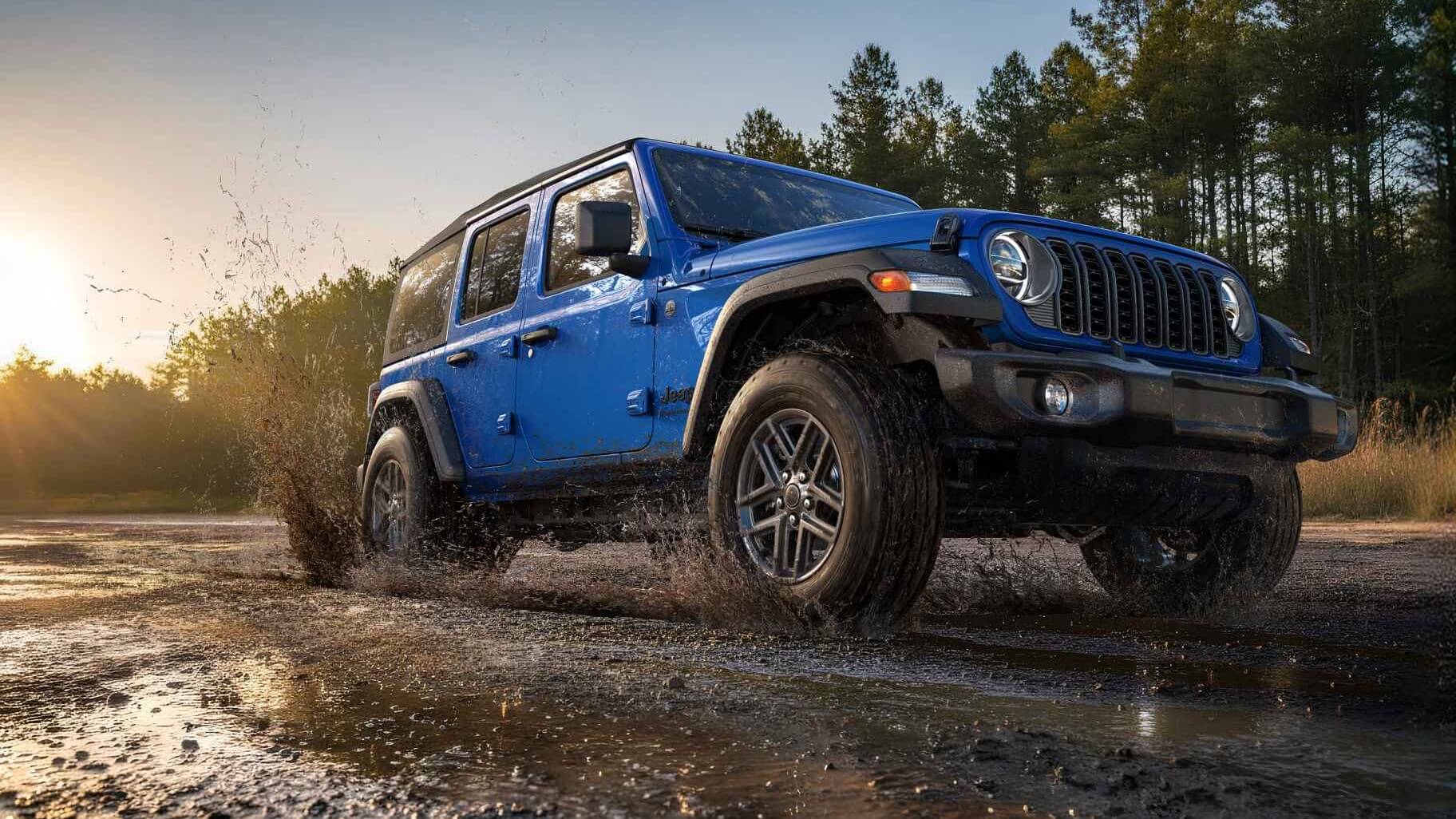 Jeep Wrangler driving through a mud trail