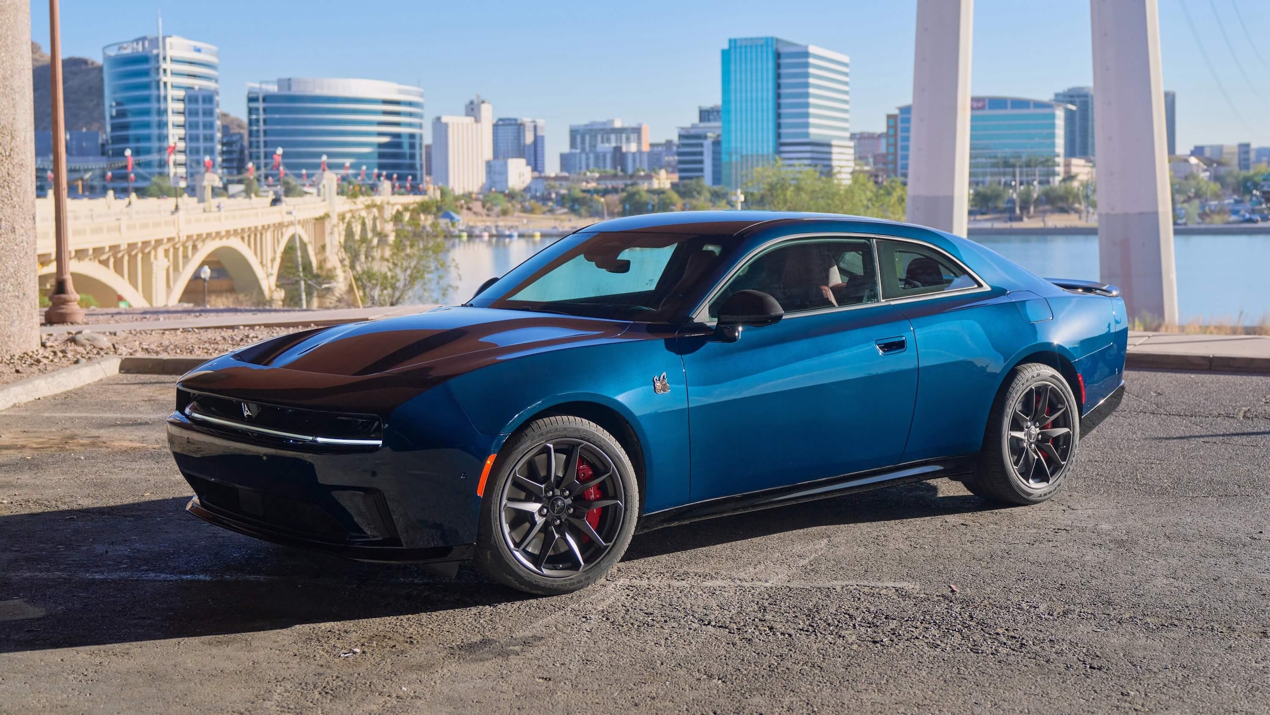Blue Dodge Charger parked at a riverside parking lot