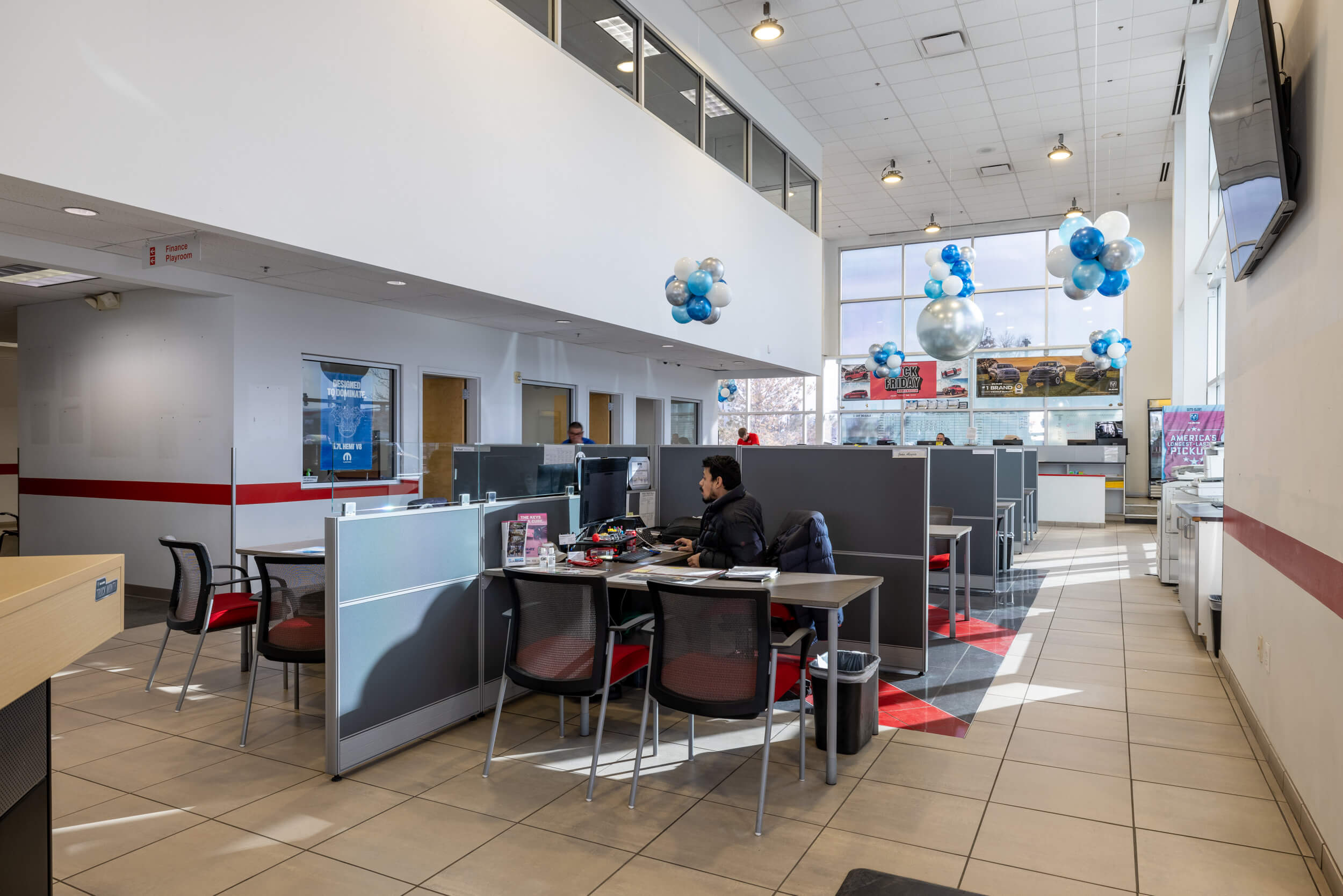 Find out about buying, servicing, and financing Dodge, Ram vehicles at AutoNation Dodge Ram Broadway Interior of AutoNation Dodge Ram Broadway in a space with bays of tables and chairs