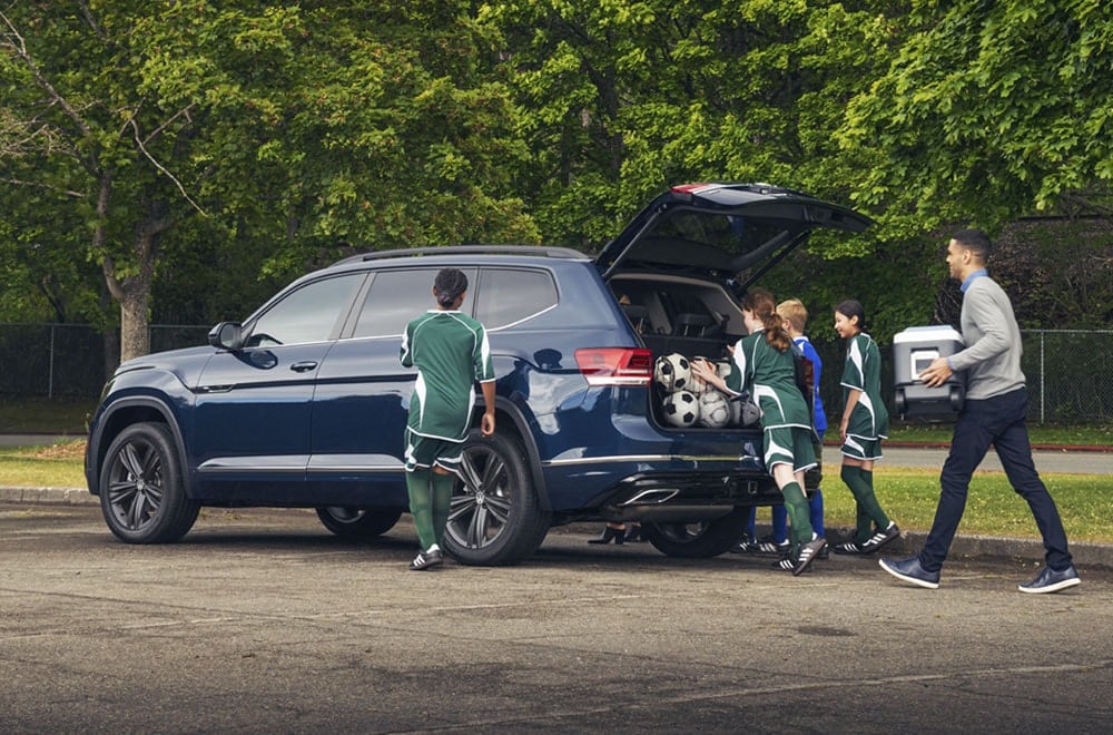 Image of a Volkswagen SUV with a family loading cargo into the back