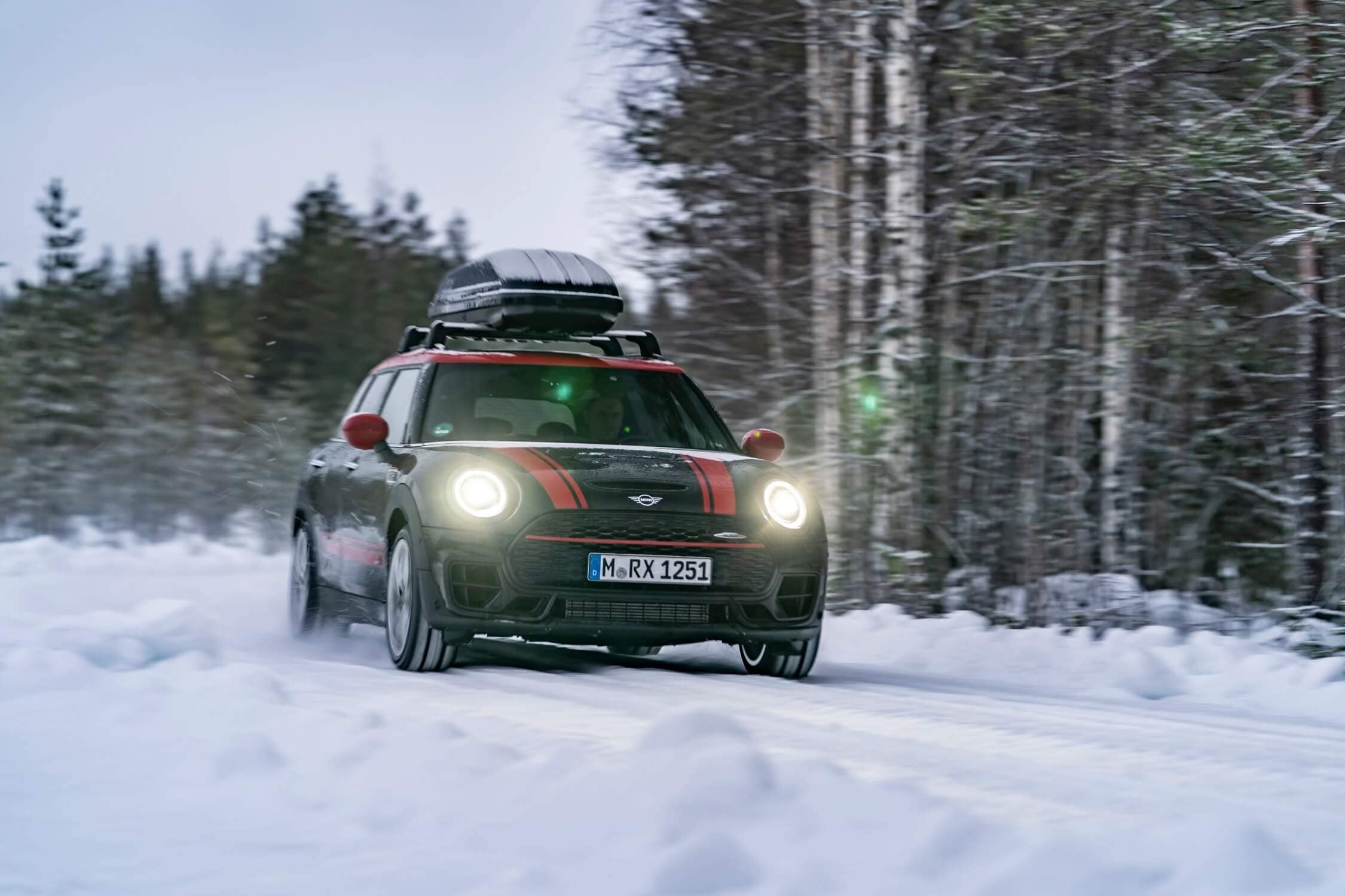 Exterior view of a MINI vehicle driving in snowy conditions
