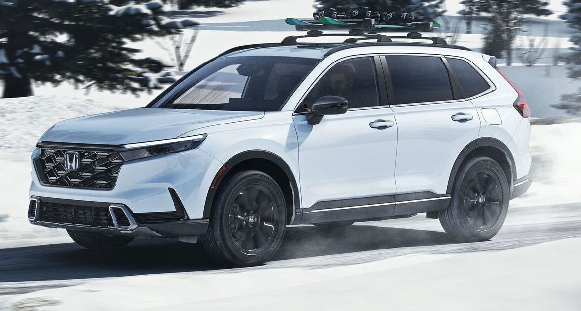 Honda CR-V in Platinum White Pearl Honda CR-V in Platinum White Pearl driving through an ice and snow-covered road during the daytime.