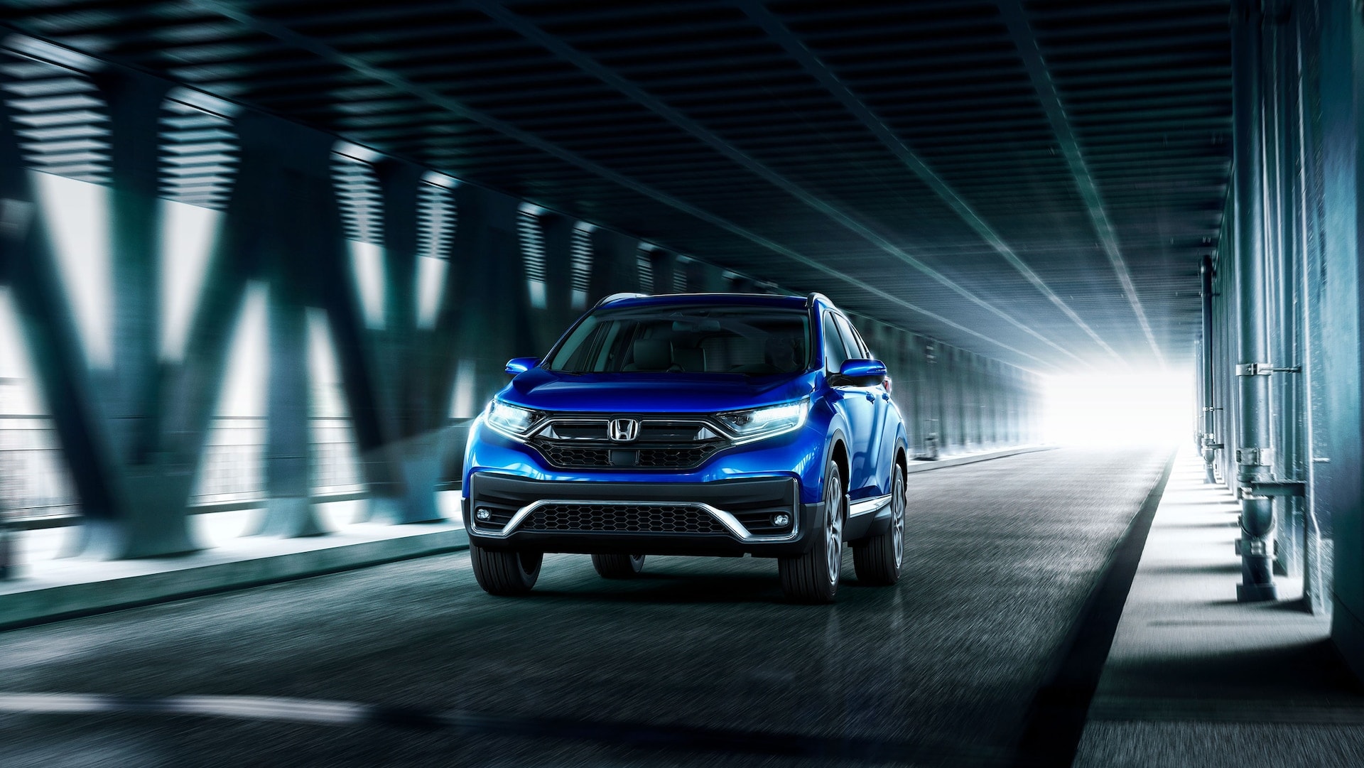 Blue Honda CR-V speeding through a tunnel