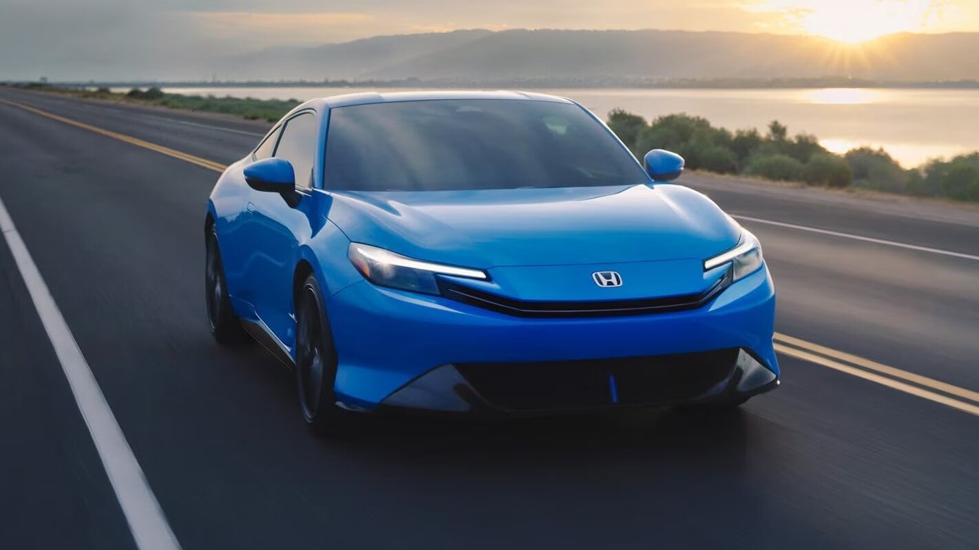 Honda Prelude driving down a lakeside highway