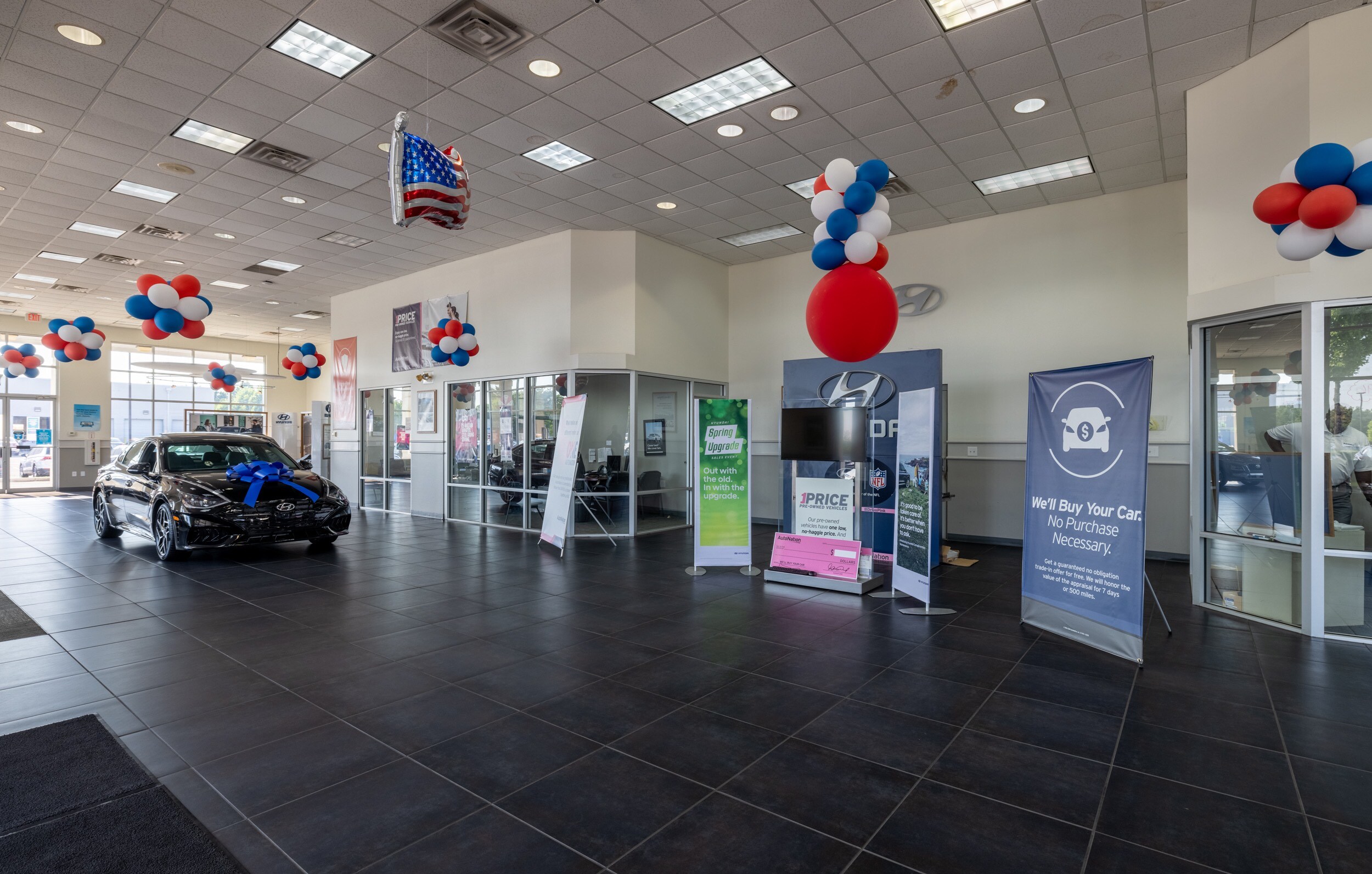 Interior view of AutoNation Hyundai Columbus, with a glass walled office in the background.