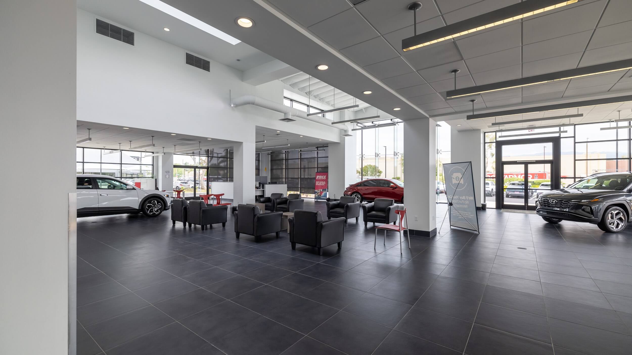 Interior shot of Hyundai of Valencia car dealership, with waiting area and cars on display