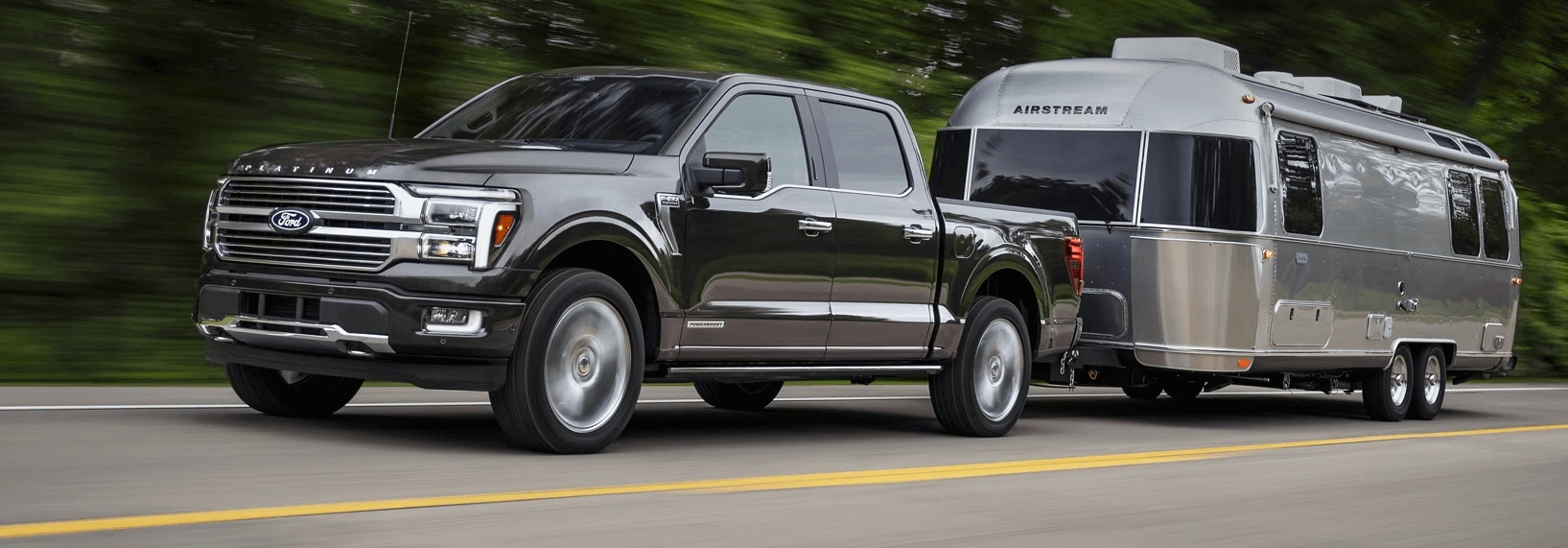 Black Ford F-150 towing an Airstream camper trailer