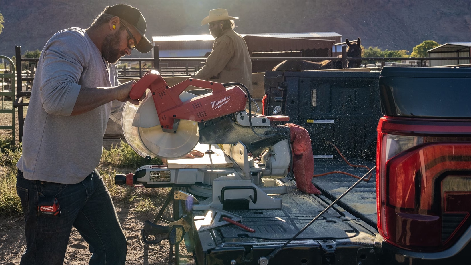 An image showing a man using Ford Pro Power Onboard to use a saw on his truckbed