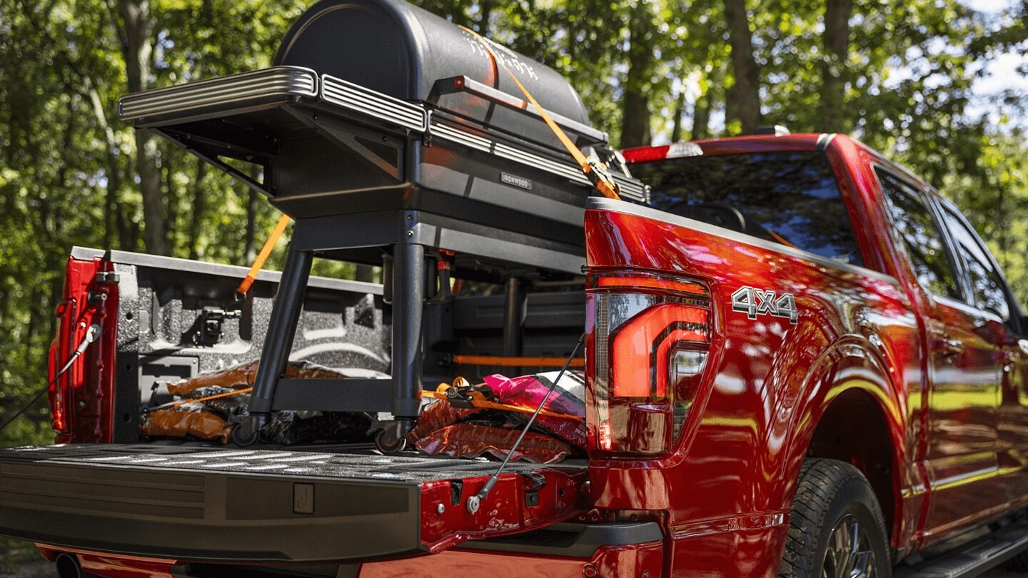 Red Ford F-150 carrying a BBQ grill in the bed