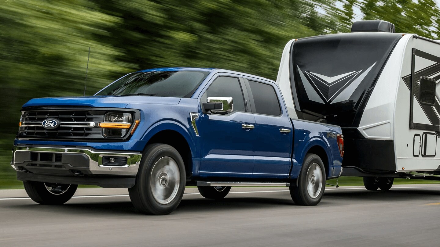 Blue Ford F-150 towing a camper trailer