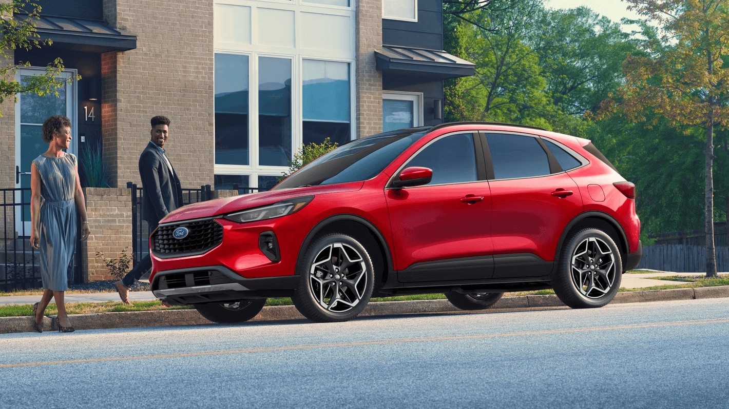 Ford Escape parked outside of a building with two people walking towards it