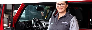 Woman service tech in front of vehicle