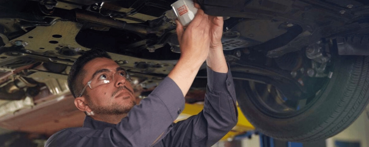 Nissan technician performing an oil change