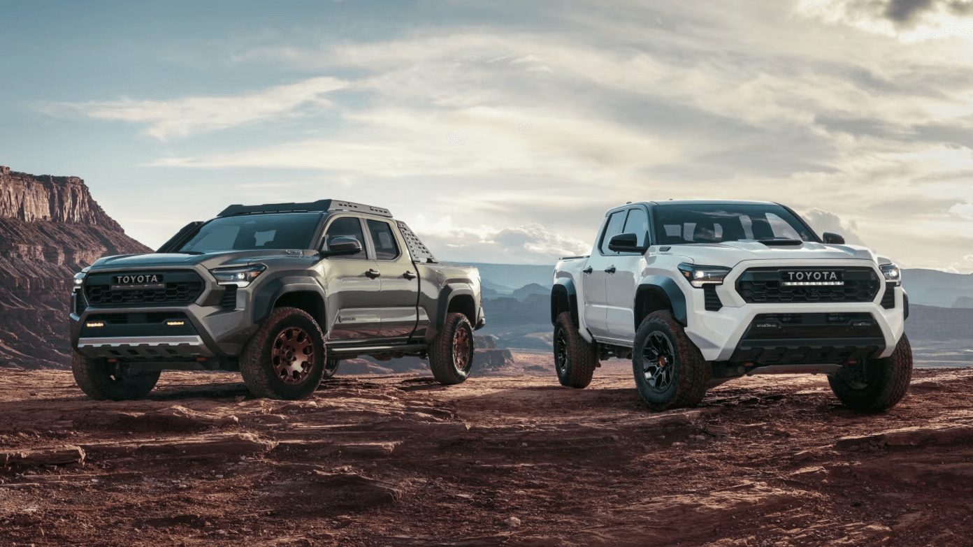 Two Toyota Tacoma trucks parked atop a cliff
