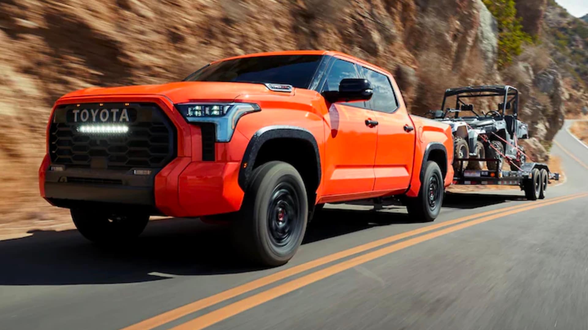 Learn about I-FORCE MAX Orange Toyota truck towing a trailer with small buggy vehicle on it