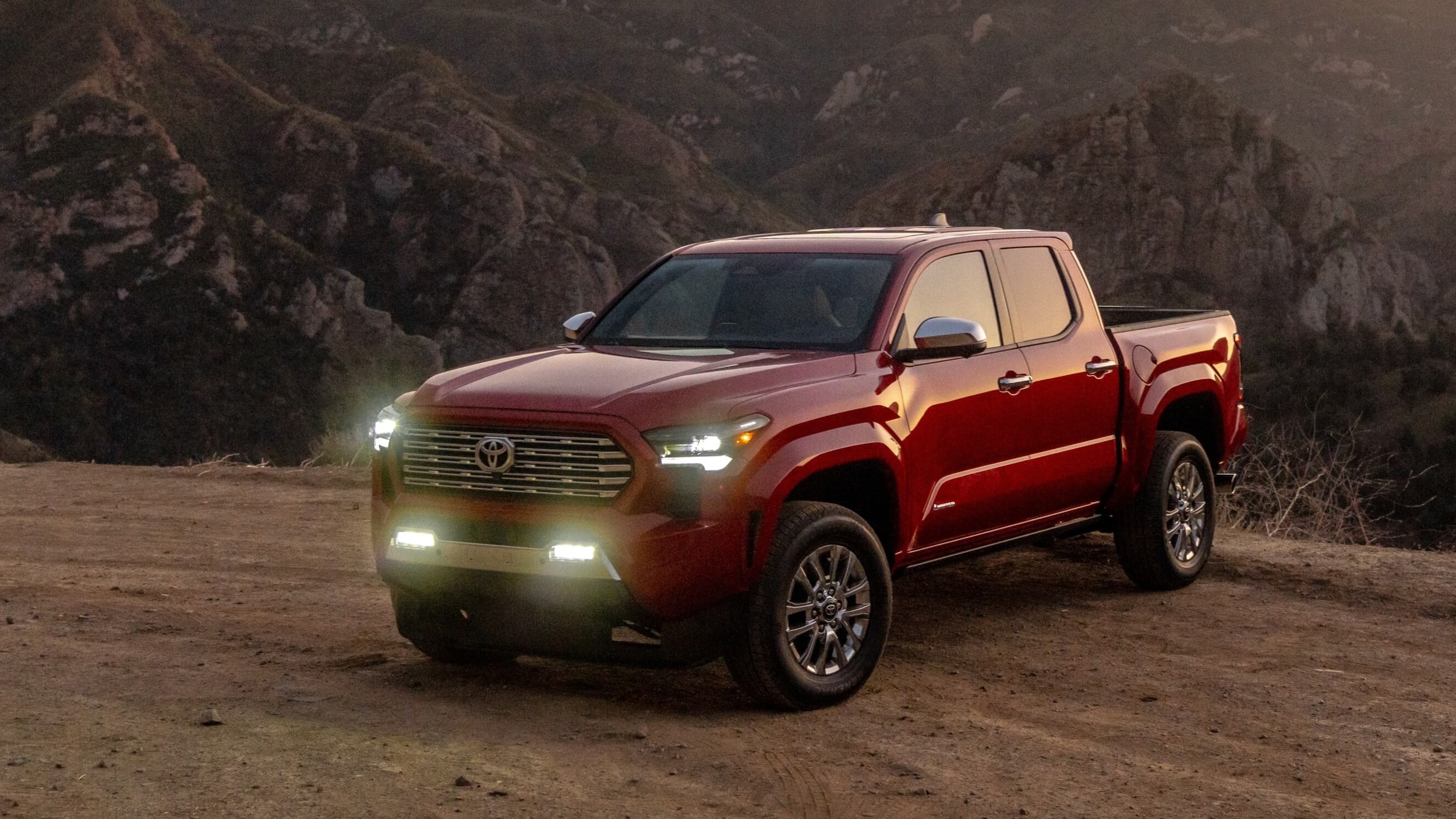 Supersonic Red Toyota Tacoma with the headlights on