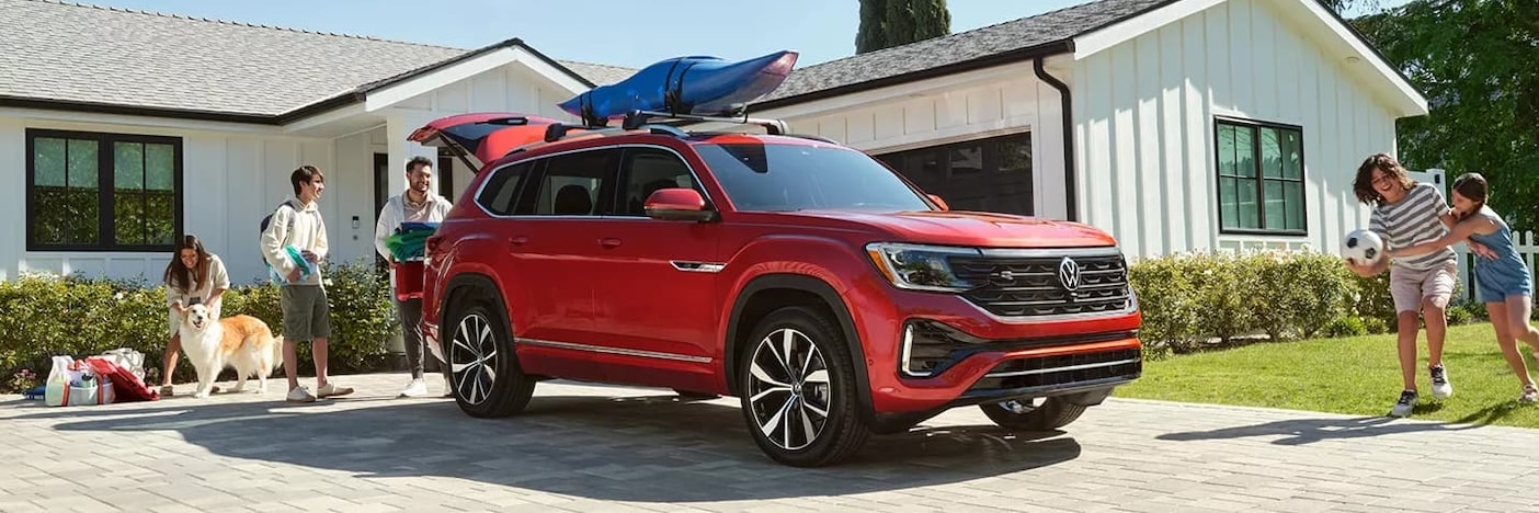 VW Atlas in a driveway with a family around it