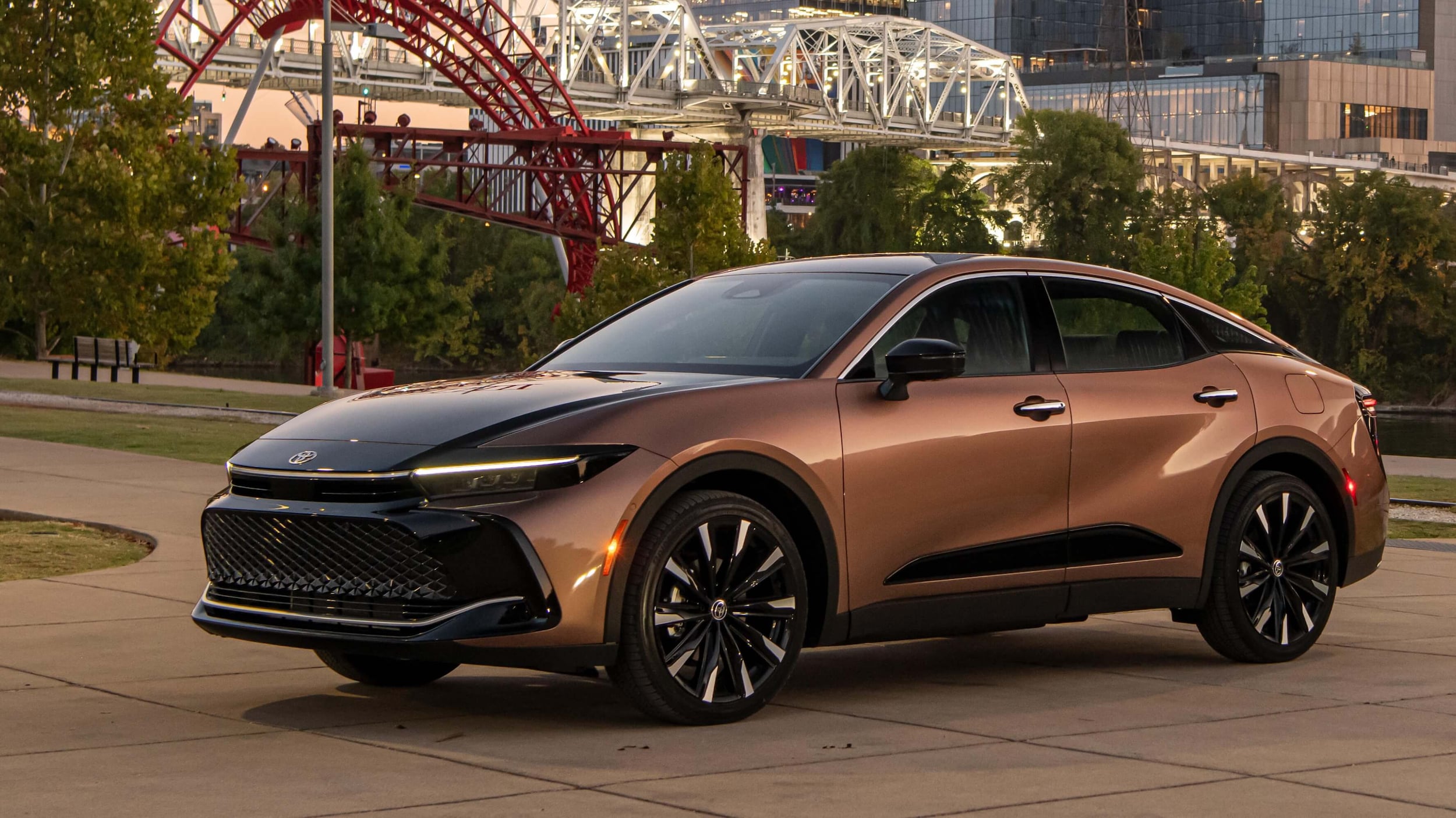 Toyota Crown parked at a park with a white bridge in the background