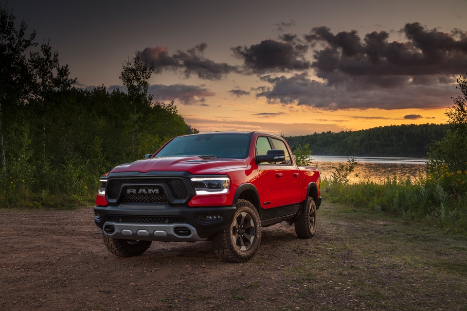 Red 2023 Ram 1500 parked in front of a lake