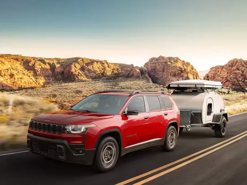 2026 Jeep Cherokee towing camper through desert highway