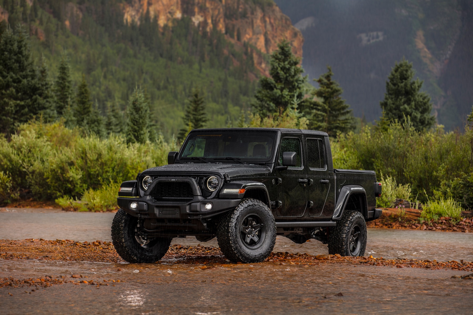 Black Jeep Gladiator parked on river bed