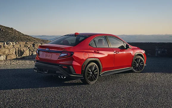 A red Subaru WRX parked on a scenic overlook