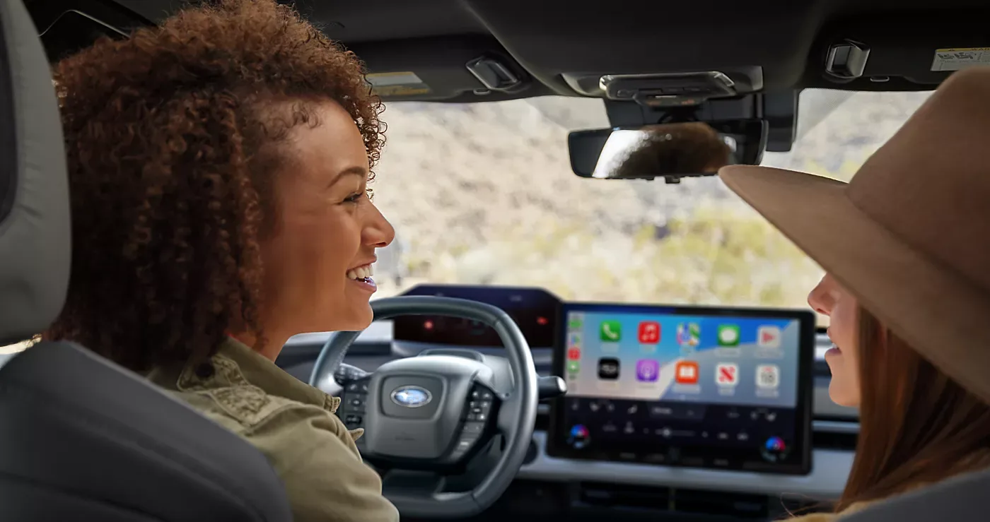 A driver and passenger using Intelligent Assistant on the Solterra touchscreen