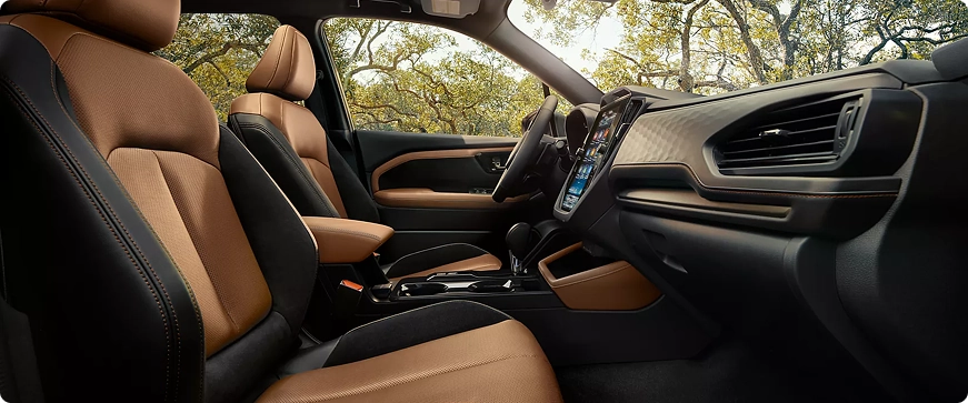 The front seats and dashboard of a Subaru Forester with tan leather upholstery