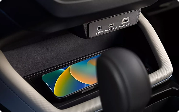 A smartphone charging on the wireless charging pad in a Subaru Forester center console