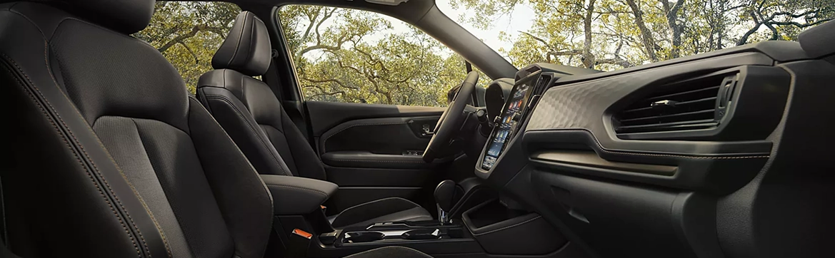 The front seats, dashboard, and vertical touchscreen of a Subaru Forester interior