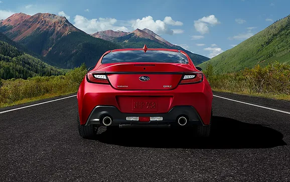 Rear view of a red Subaru BRZ with mountains behind