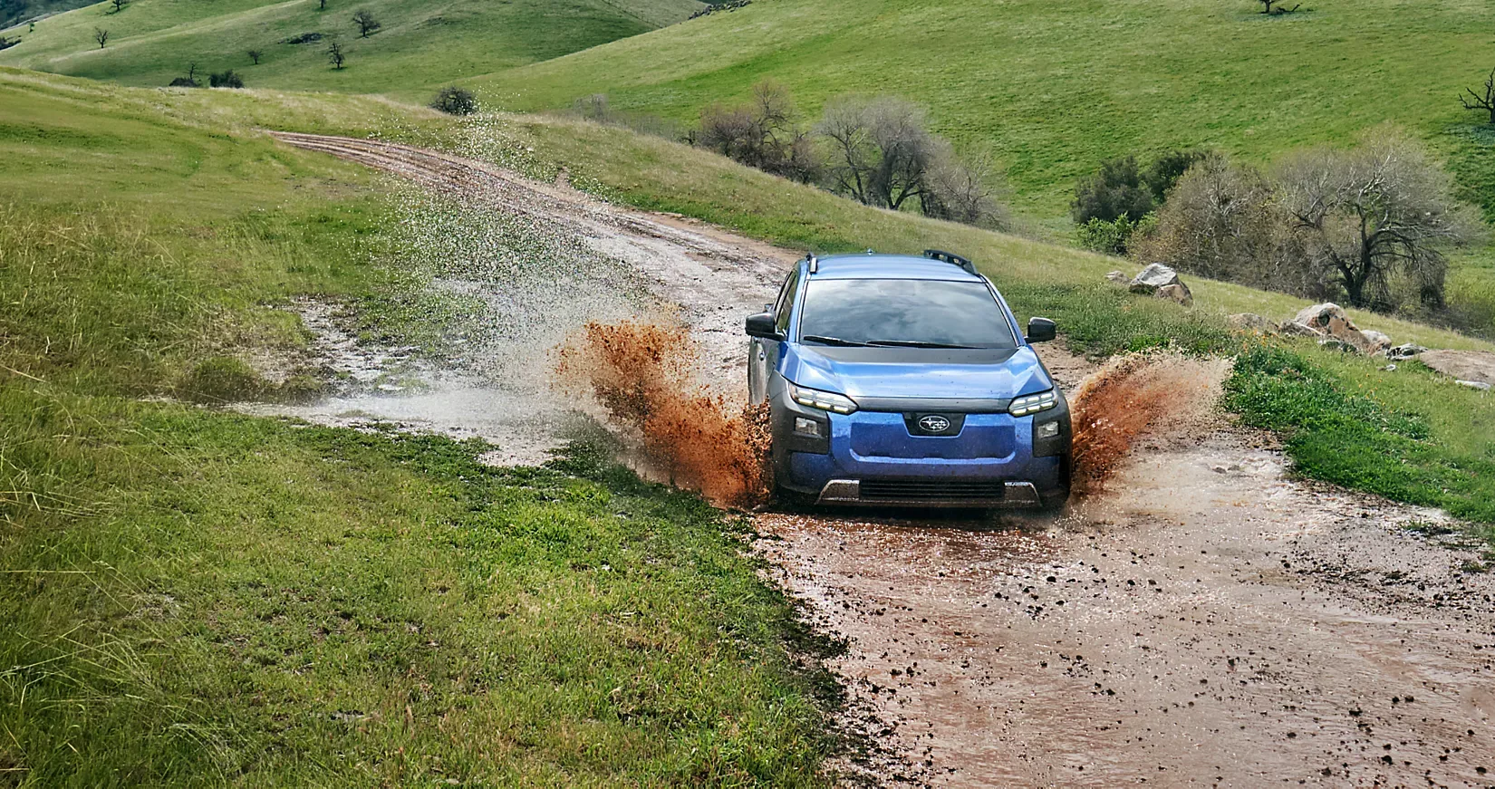 A Subaru Trailseeker climbing a muddy trail