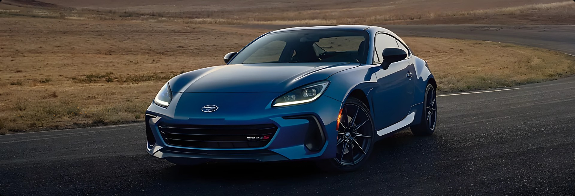 A blue Subaru BRZ tS on an open desert road at dusk