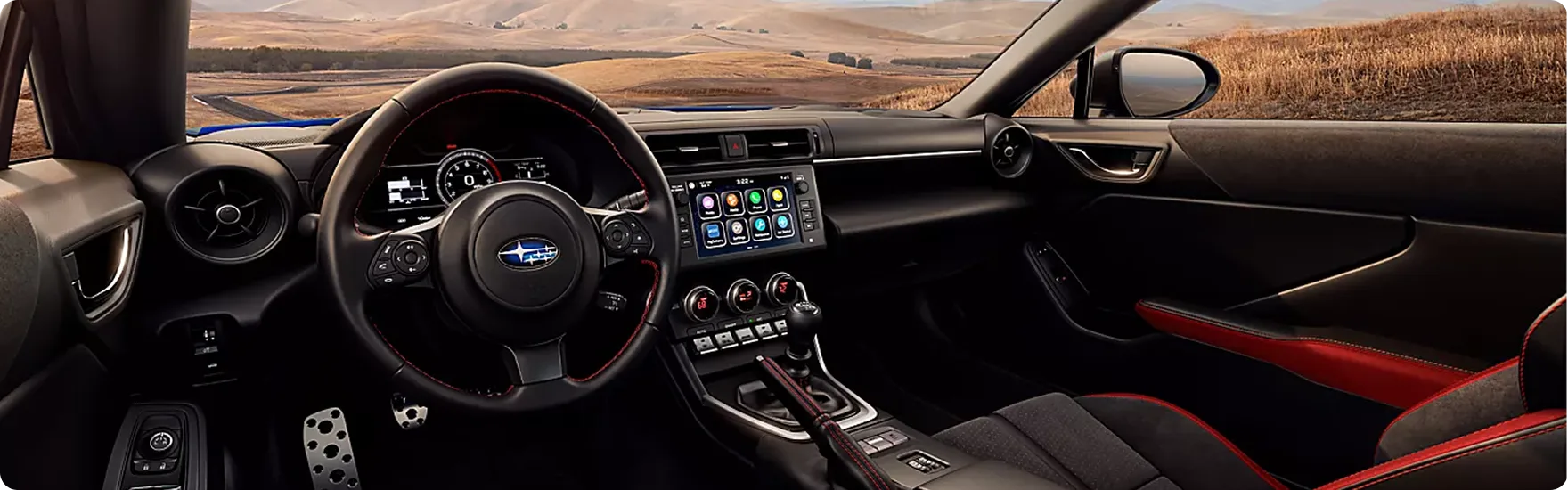 Driver’s view of the BRZ cockpit with red-accented trim and open road ahead