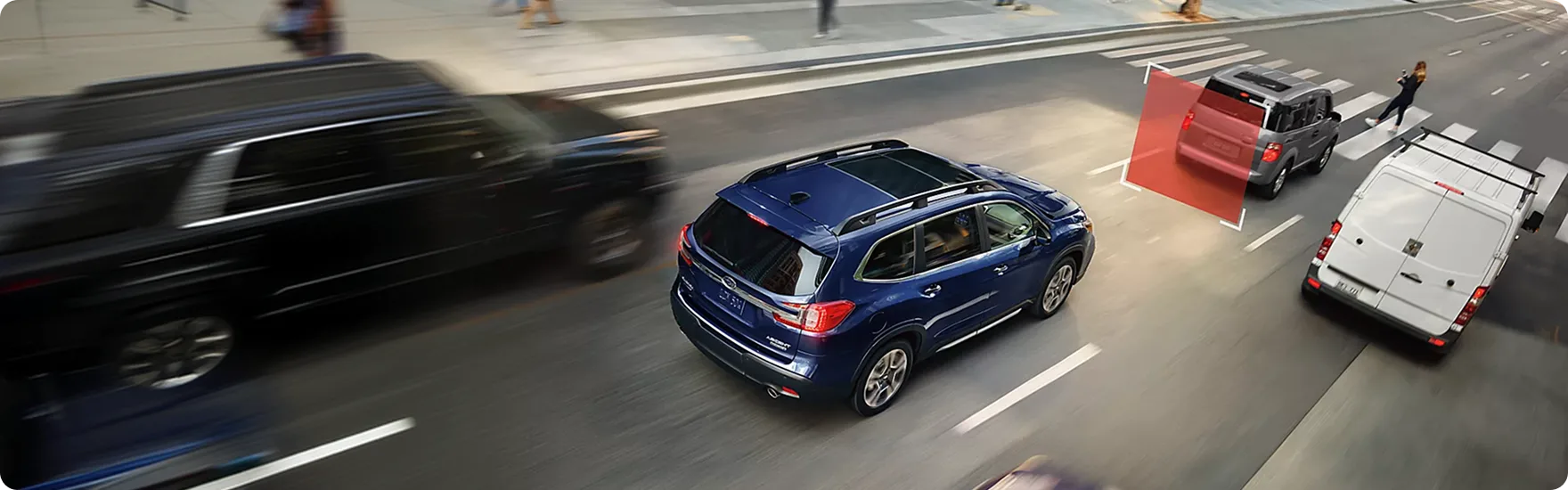 A blue Subaru Ascent braking on a city street as traffic blurs past