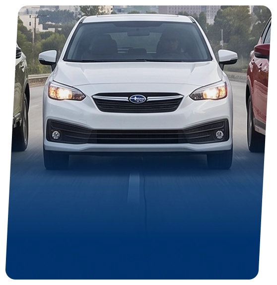 A white Subaru Impreza hatchback on a city street