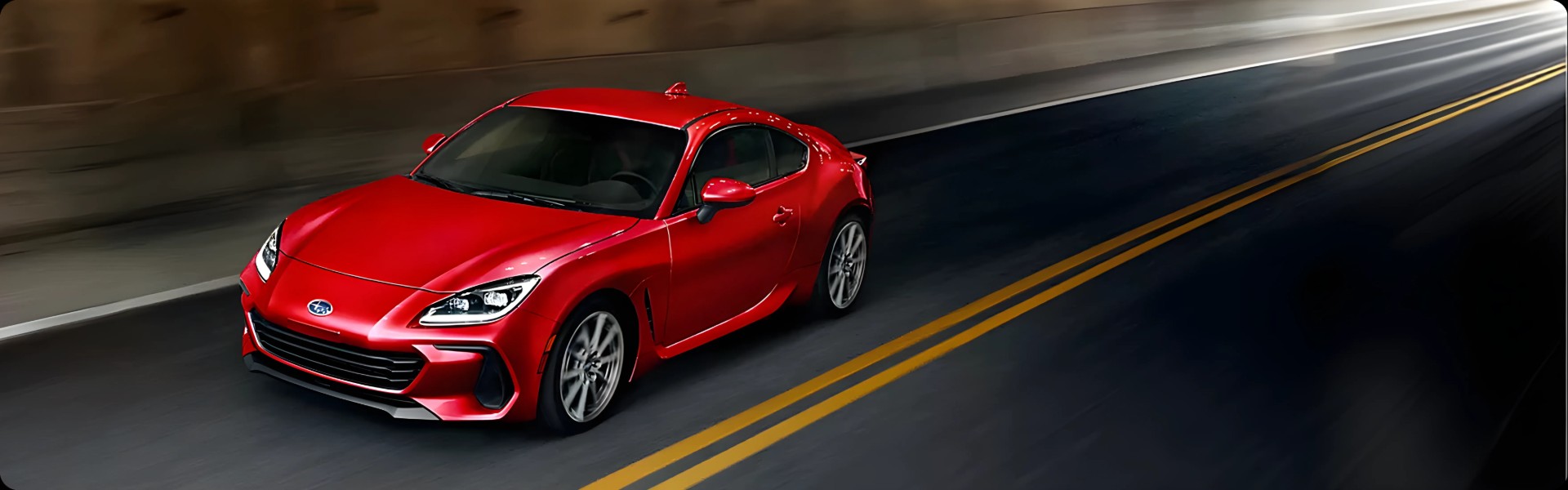A red Subaru BRZ accelerating along a highway