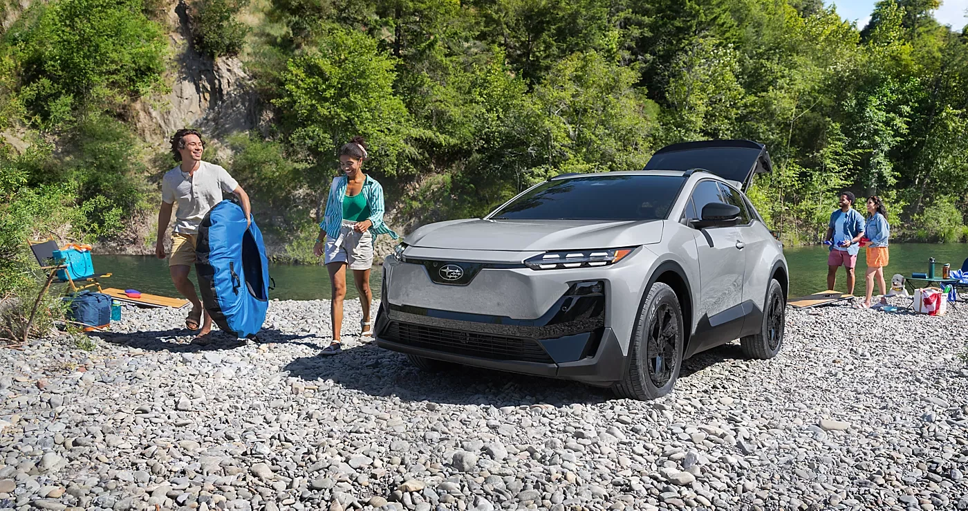 Hikers on a national park trail beside a parked Subaru Uncharted